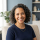 A smiling, diverse woman looking at the camera in a bright, professional studio setting.